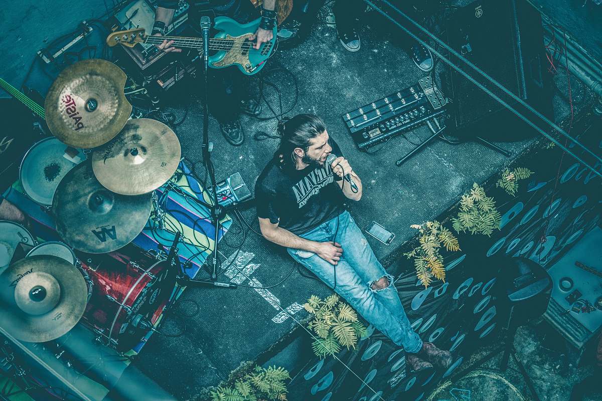 portugal man sitting while singing beside instruments man